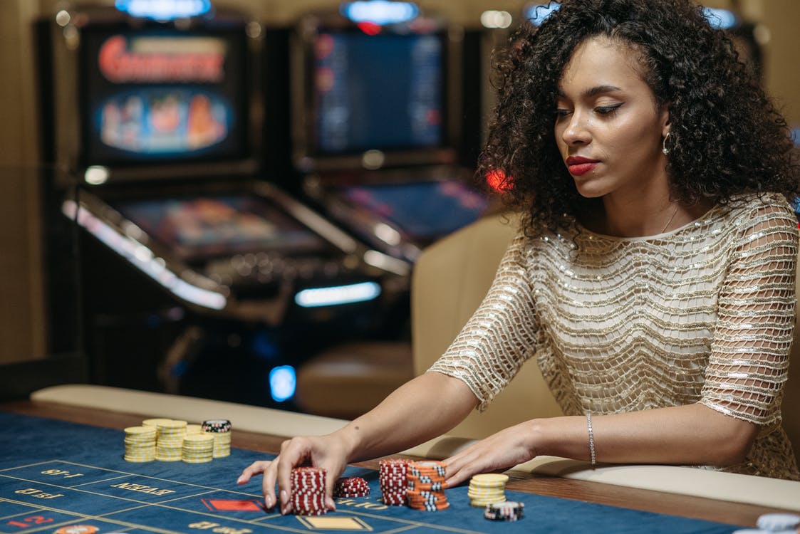 Free A Woman Betting a Stack of Chips on a Gaming Table Stock Photo